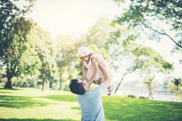 Father throws his daughter up high against, happy time family.