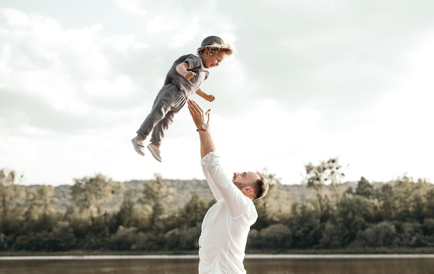 Father tossing happy kid in air