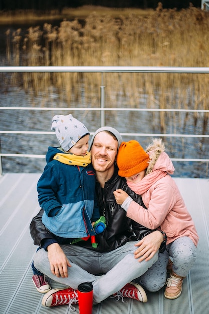 Father and two children walk in nature in autumn spend time together have fun