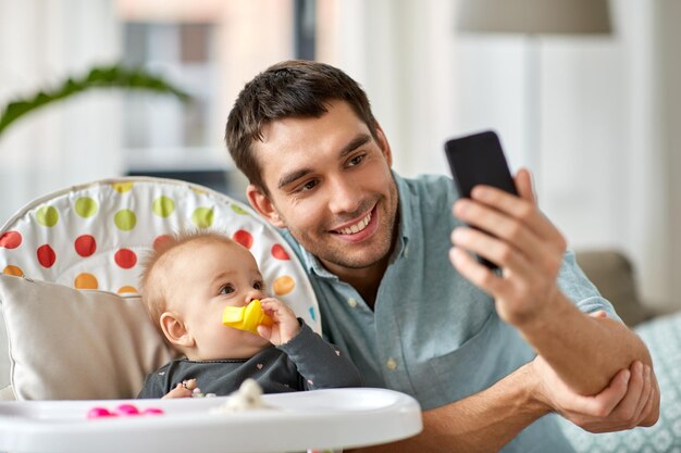 Photo father with baby daughter taking selfie at home