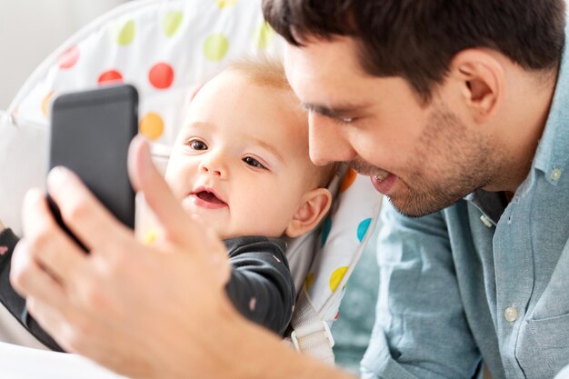 Photo father with baby daughter taking selfie at home