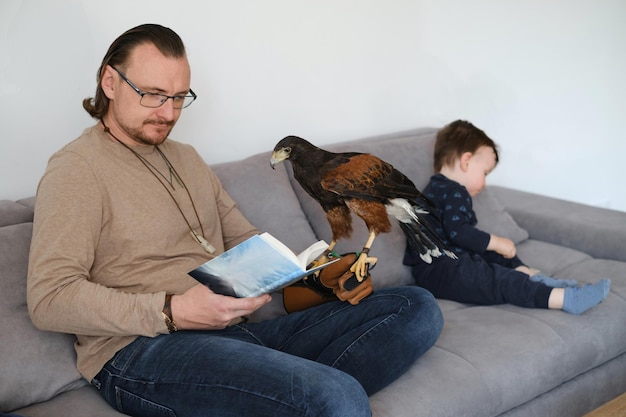 Father with child and wild bird eagle sitting on the coach