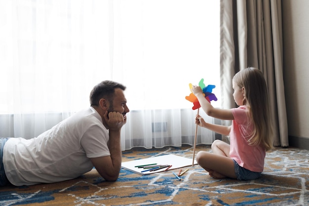 father with cute little daughter drawing at home