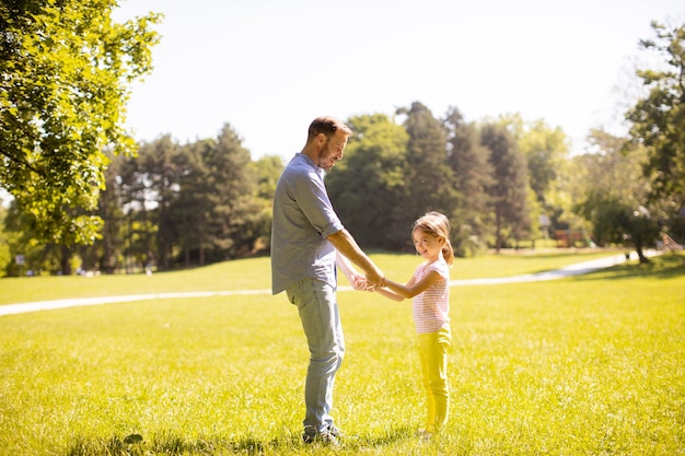 Father with daughter having fun on the grass at the park