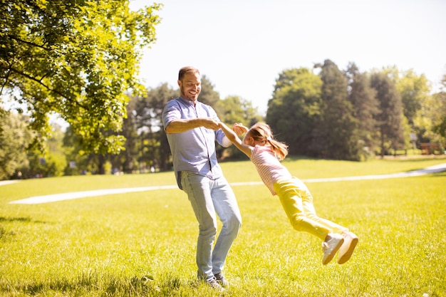 Father with daughter having fun on the grass at the park