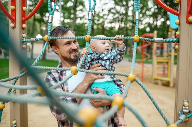 Father with his little son on playground in summer park