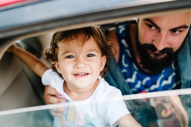 Father with little daughter sitting in a car on streets in city of Tbilisi in the capital of Georgia on sunny spring day Dad and girl travel on excursion in old town