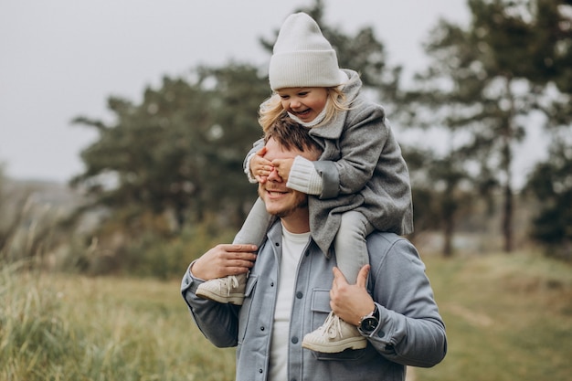 Father with little daughter together in autumnal weather having fun