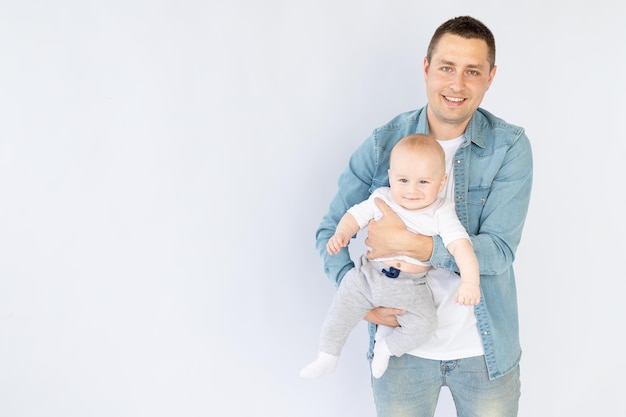 A father with a small child son on a white isolated empty background in a photo studio playing hugging Happy fatherhood or family