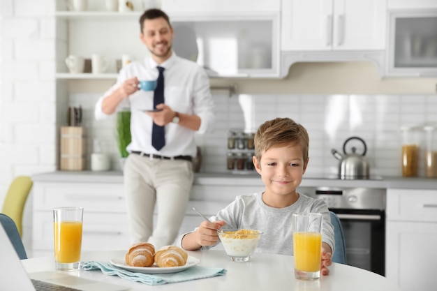 Father with son having breakfast in kitchen