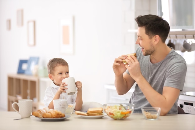 Father with son having breakfast in kitchen