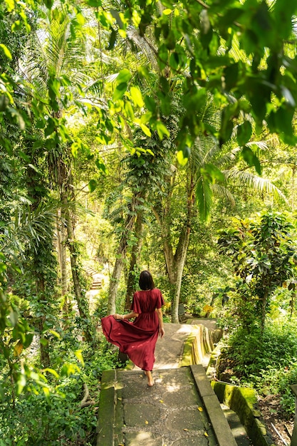 Favorite place. Kind female person looking forward while running downstairs on stone path, exotic nature