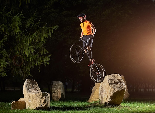 Fearless guy doing trick while standing on a bike