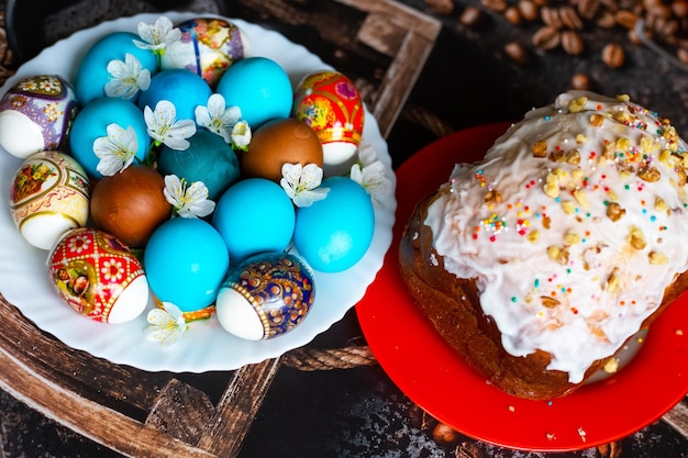 The Feast of Holy Easter Painted eggs and Easter cakes on platters decorated with cherry blossoms