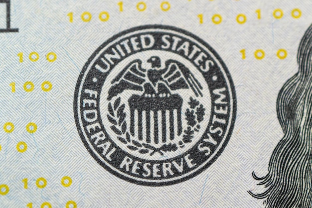 Federal reserve system logo us federal reserve emblem on hundred dollars banknote as fed consider in