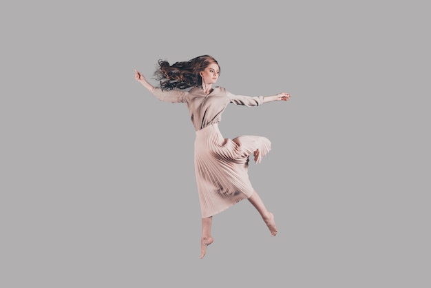 Feeling freedom of every move. Studio shot of attractive young woman hovering in air