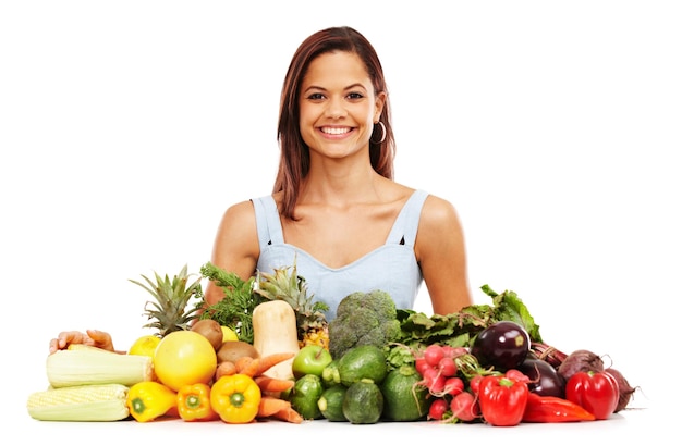 Feeling great about healthy choices Smiling young woman alongside an assortment of healthy and fresh vegetables