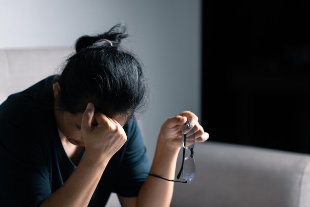 Feeling tired and stressed young woman of working age is working in the living room of the house