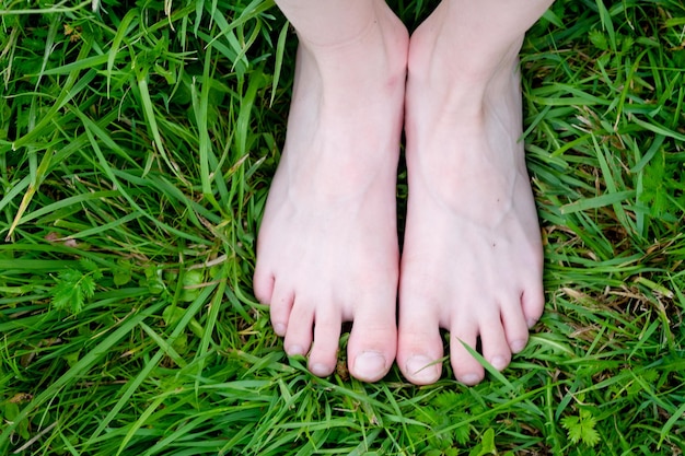 Feet barefoot on the grass top view