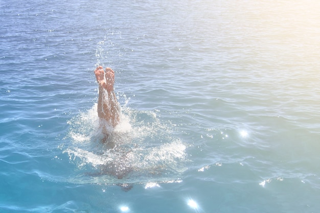 Feet of a man jumping into the ocean