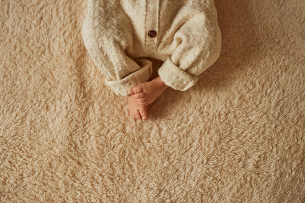 Feet of a newborn the baby is dressed in a warm knitted suit