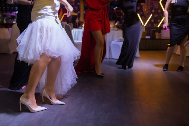 Feet of people dancing on a club party unrecognizable