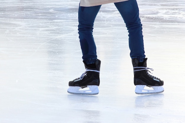 Feet on the skates of a person rolling on the ice rink