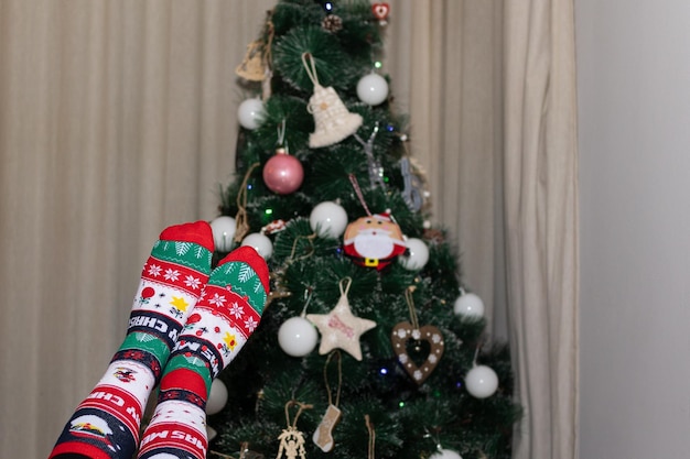 Feet with socks up with defocused christmas tree in the background