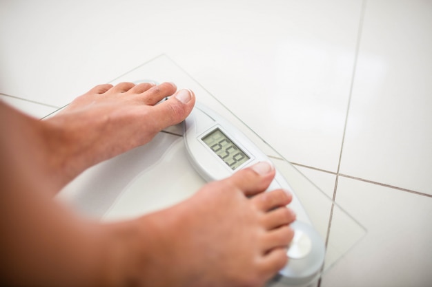 Feet of woman on weighting scale at home