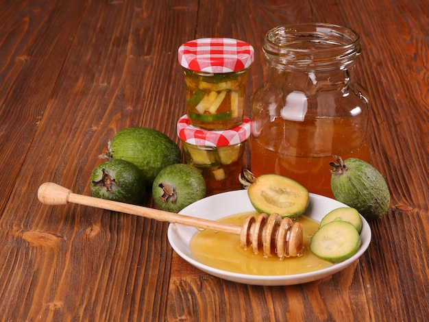 Feijoa Fruits with honey on a wooden table