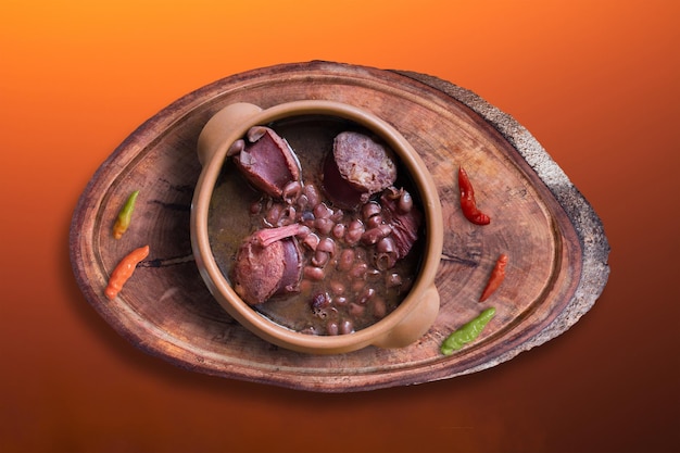 Feijoada in ceramic pot with gradient colored background