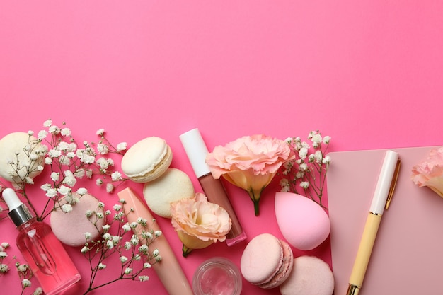 Female accessories and macaroons on pink background