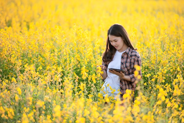 Female agricultural researcher examines plants that can be grown to nourish the soil and also have beautiful flowers in Asia