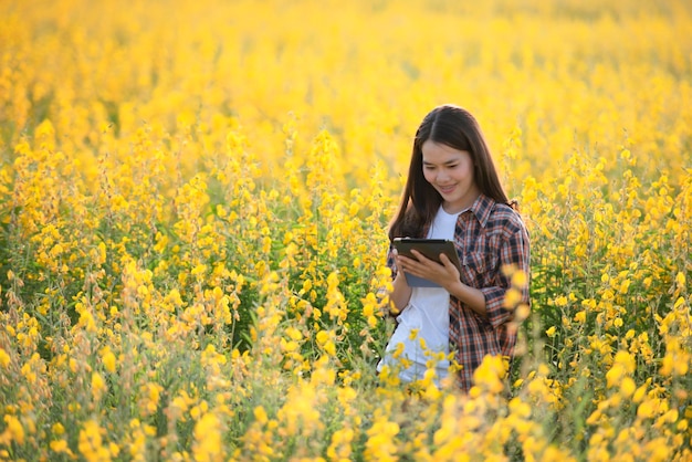 Female agricultural researcher examines plants that can be grown to nourish the soil and also have beautiful flowers in Asia