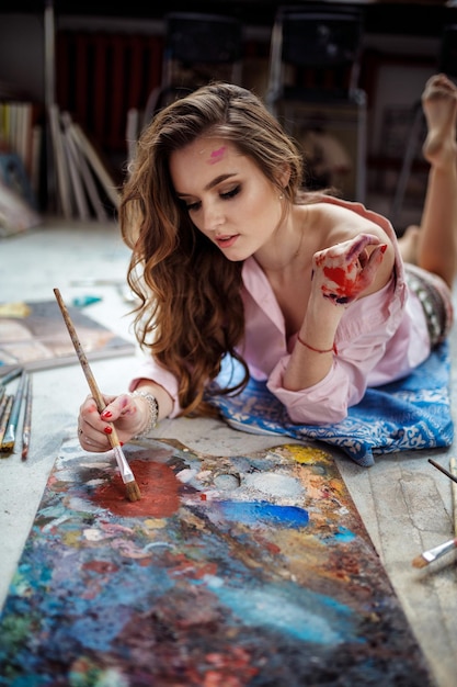 Female Artist Working On Painting In Studiox9