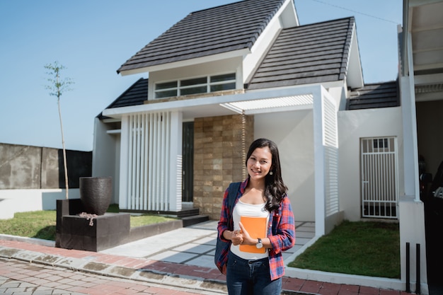 Female asian student in front of her house