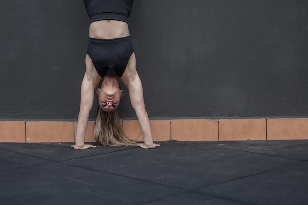 Female athlete doing handstand during training