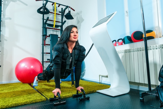 The female athlete doing they exercise in the EMS fitness studio