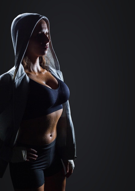 Female athlete with hoodie against dark grey background