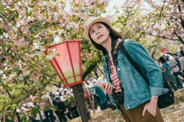 Female backpacker in spring park with sakura