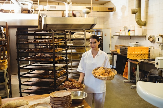 Female baker holding basket of sweet foods