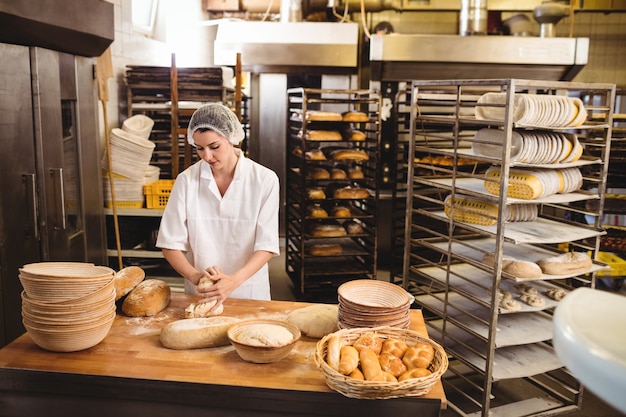 Female baker kneading a dough