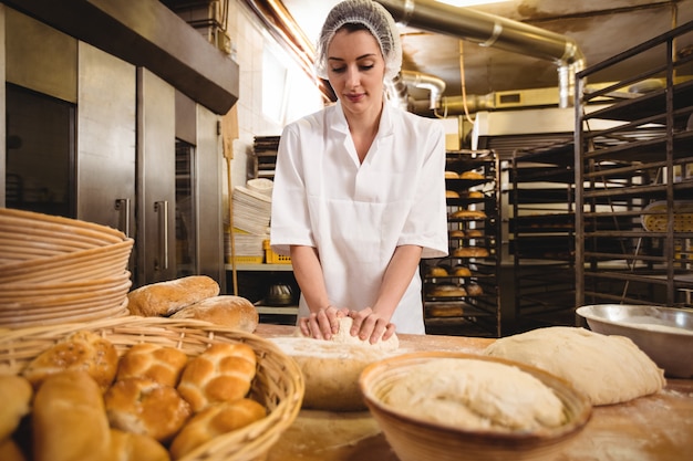 Female baker kneading a dough