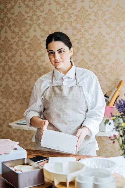 Female baker pastry chef preparing cake order arabic asian woman making cake for online delivery