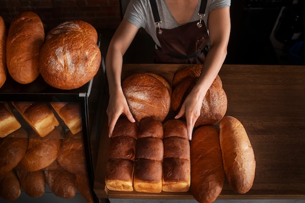 Female baker with baked bread in the pastry shop