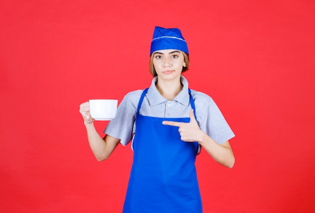 Female barista holding a white big cup