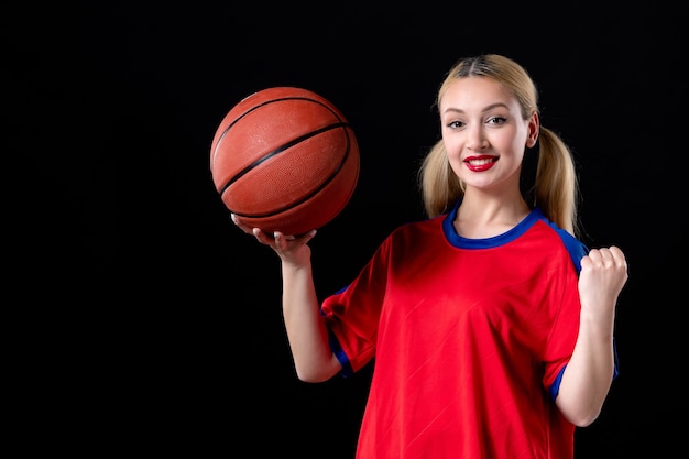 female basketball player in sport clothes with ball on black background exercise game