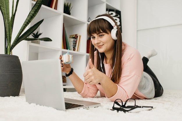 Female blogger streaming at home with laptop and headphones