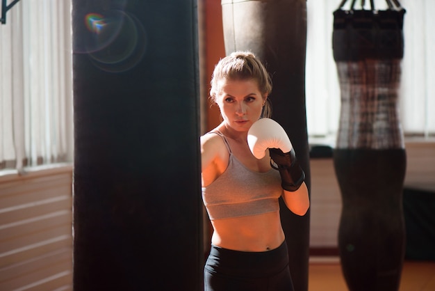 A female boxer train hard in a boxing studio.