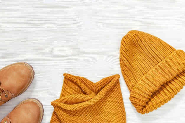 Female bright orange clothing, warm wool knitted scarf, cap and cozy shoes. Shopping overview concept with copy space. Fashion concept. Top view. Flat lay.